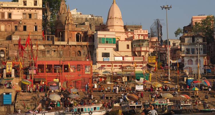 La lumière dorée du soir baigne les marches animées du front de rivière et les temples de Varanasi.