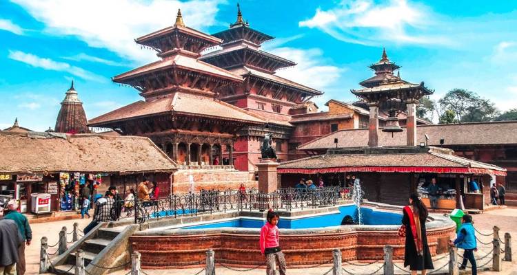 Place Durbar animée avec des temples pagodes à étages, des vendeurs et des visiteurs sous un ciel lumineux.