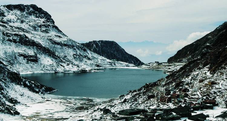 Schneebedeckte Berge umgeben die eisig blauen Wasser des Tsomgo-Sees.
