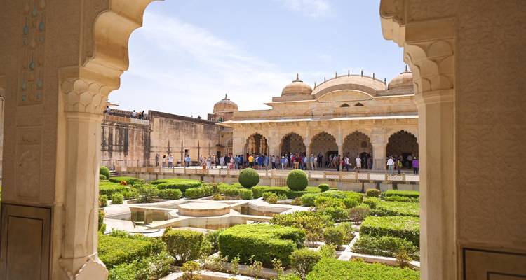 Vue à travers une arche ornée sur une cour et des jardins à l'intérieur du Fort d'Amber.