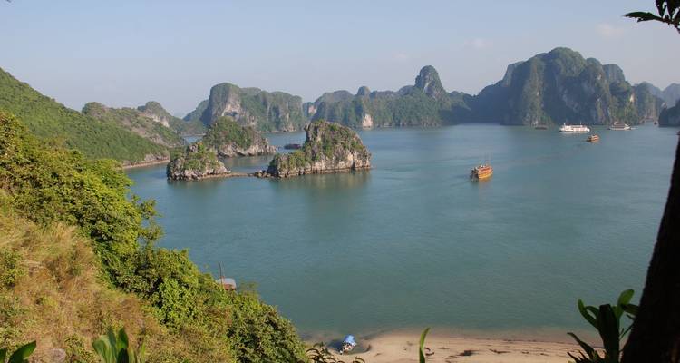 Des îles karstiques calcaires s'élèvent des eaux émeraude calmes de la baie d'Halong.