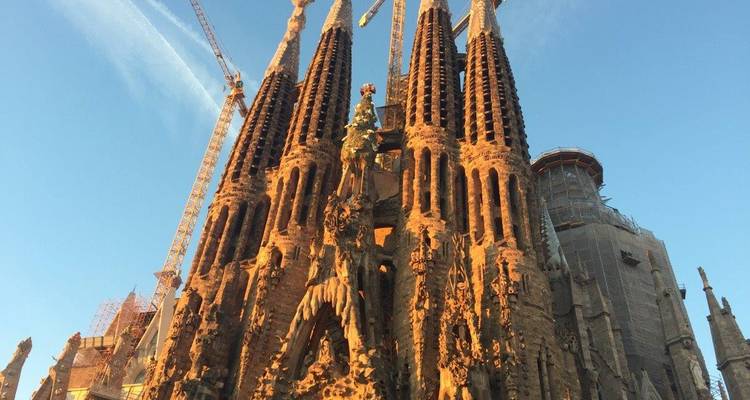 Les flèches élancées et les façades complexes de la Sagrada Família s'élèvent contre un ciel clair.