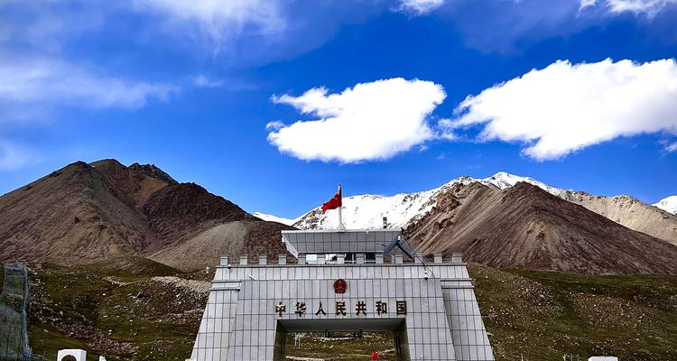 Khunjerab Pass gate of China–Pakistan border with snow-capped peaks and blue sky.