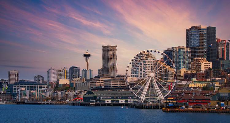 Front de mer de Seattle au crépuscule avec grande roue, Space Needle et ciel de coucher de soleil vibrant.