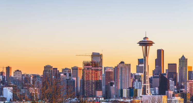 Horizon de Seattle au lever du soleil avec un ciel dégradé clair et la Space Needle en silhouette.