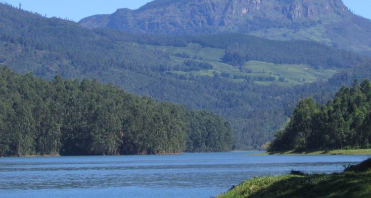 Réservoir bleu calme entouré d'une forêt dense et de pics imposants des Ghâts occidentaux.
