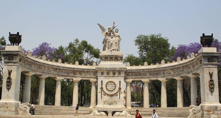 White marble Hemiciclo a Juárez monument framed by purple jacaranda trees