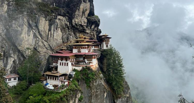 Spectaculaire monastère du Nid du Tigre accroché à une falaise enveloppée de brume au Bhoutan.