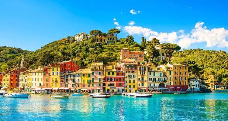 Des maisons aux couleurs pastel éclatantes bordant un port ligurien pittoresque adossé à des collines luxuriantes