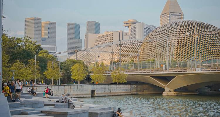 Promenade moderne du front de mer à Singapour avec le théâtre Esplanade aux piques et les gratte-ciel de la ville en arrière-plan.