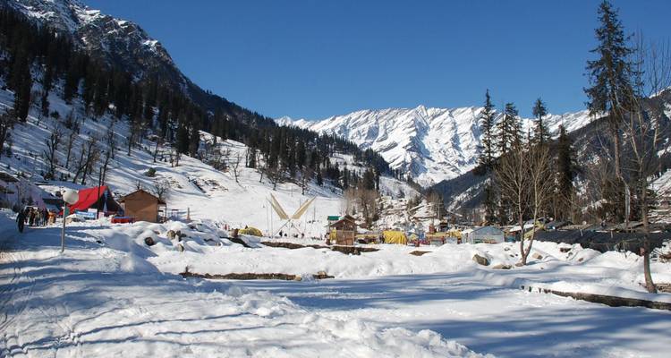 Schneebedecktes Tal und Kiefernwälder unter den aufragenden Gipfeln nahe dem Rohtang-Pass.