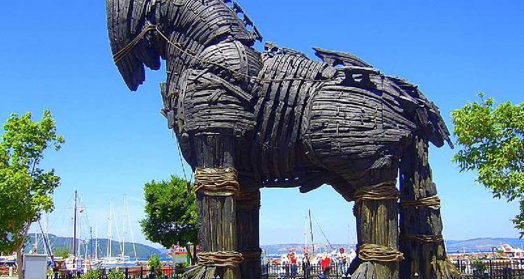 Dark wooden Trojan Horse movie prop displayed on a waterfront promenade.