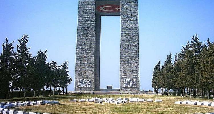 Çanakkale Martyrs Memorial gate towers above landscaped grounds and circular graves.