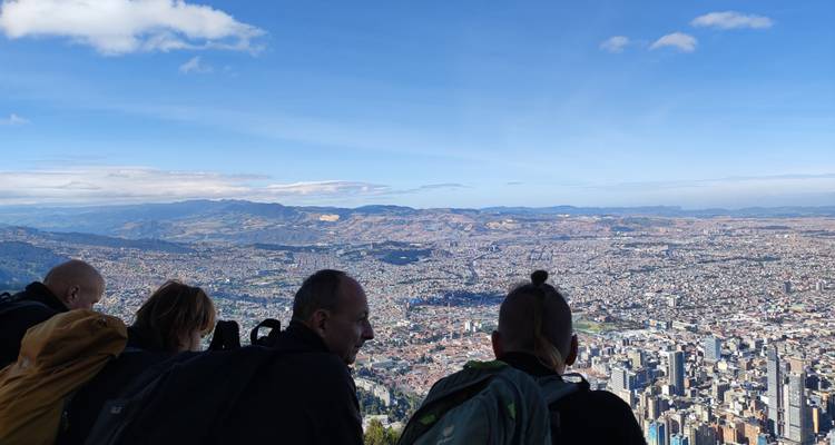 Les voyageurs s'appuyant sur une rampe profitant d'une vue aérienne expansive sur le paysage urbain de Bogotá