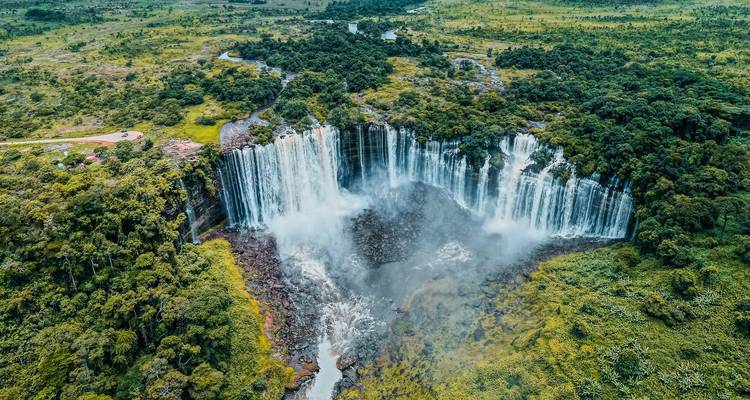Prise de vue aérienne d'une cascade de prêle massive plongeant d'une falaise verdoyante luxuriante dans un bassin brumeux.