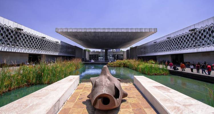 Wasserbecken und charakteristisches schwebendes Dach des Nationalen Anthropologiemuseums von Mexiko-Stadt an einem sonnigen Nachmittag