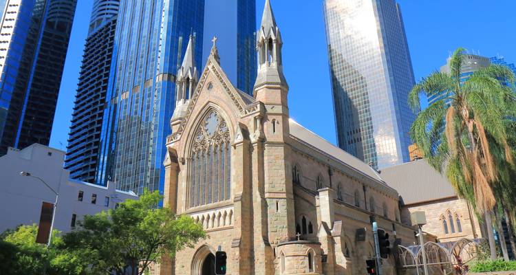 Catedral histórica de piedra enmarcada por rascacielos modernos de cristal en el centro de Brisbane