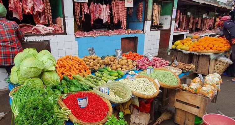 Un étal de marché animé déborde de produits frais, de viandes et d'épices aux couleurs éclatantes.