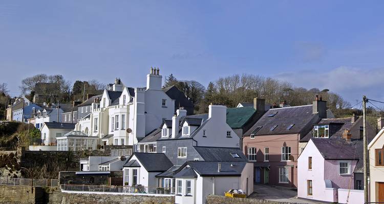 Charmantes Küstendorf in Irland mit farbenfrohen Häusern und klarem blauen Himmel