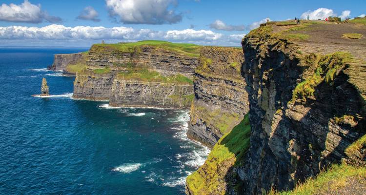 Dramatic Cliffs of Moher rising above the Atlantic with sea stacks and crashing waves