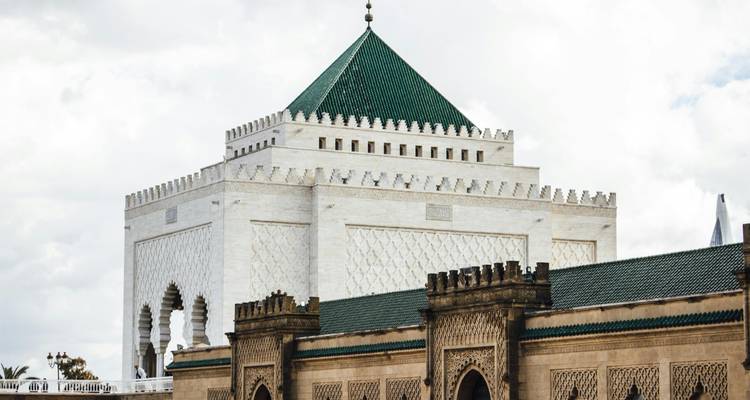 Mausolée en marbre blanc de Mohammed V avec toit aux tuiles vertes sous un ciel nuageux à Rabat.