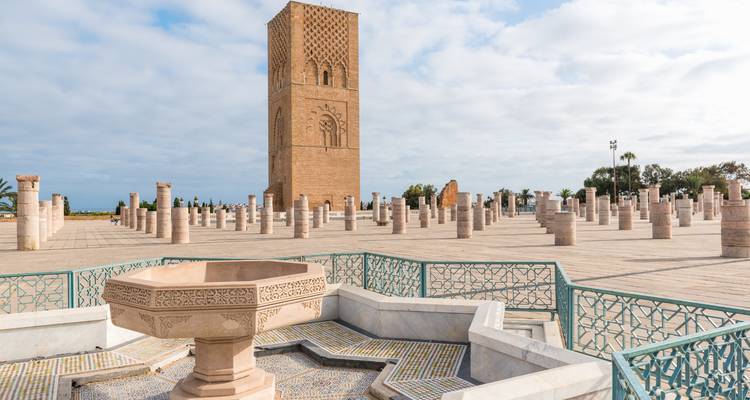 La Tour Hassan s'élève au-dessus d'une place ornée de colonnes en marbre et d'une fontaine carrelée à Rabat.