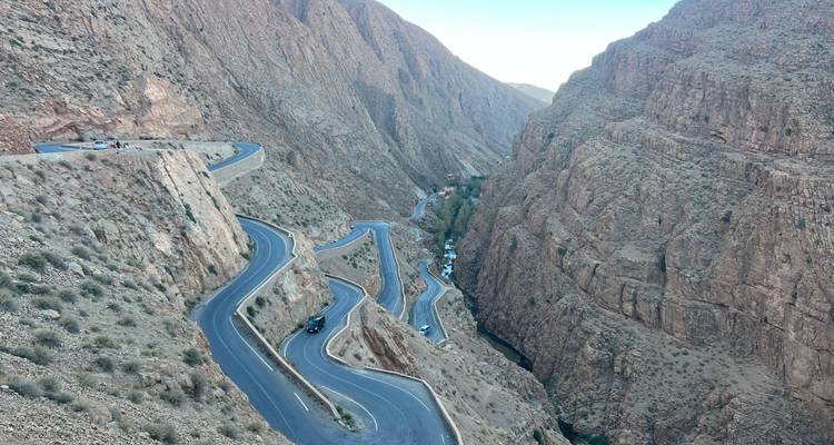 Une route sinueuse spectaculaire serpente à travers les falaises rocheuses escarpées d'un canyon profond
