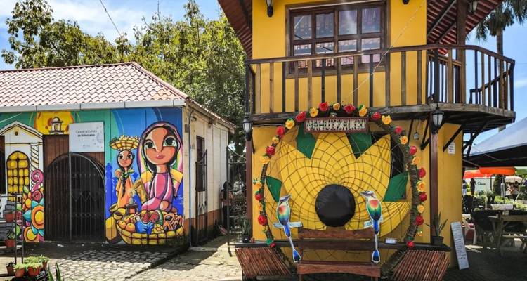Murales coloridos y escaparates decorativos en un pintoresco pueblo de adoquines.