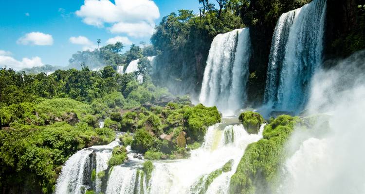 Puissantes cascades des chutes d'Iguazu plongeant au milieu d'une jungle verdoyante luxuriante sous un soleil éclatant.