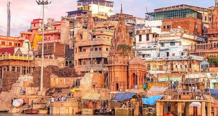 Templos coloridos, santuarios y edificios junto al río se agolpan en los ghats sagrados de Varanasi al anochecer.