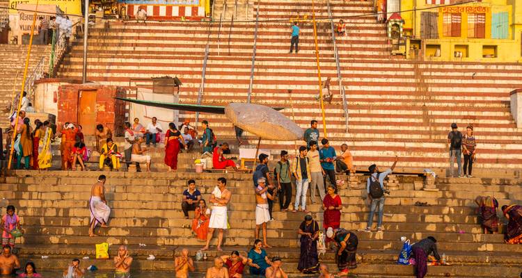 Gran multitud bañándose y socializando en los escalones de un ghat vibrante a lo largo del río Ganges.