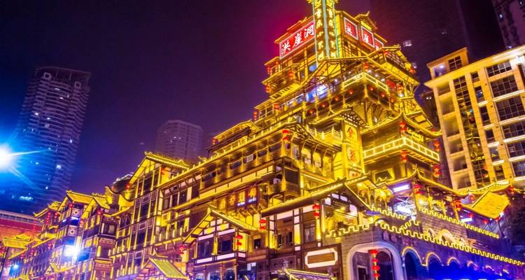 Scène nocturne du complexe Hongyadong de style traditionnel brillamment illuminé à Chongqing.