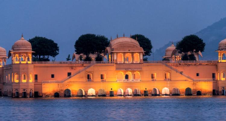 Beleuchteter Jal Mahal Wasserpalast, der bei Dämmerung auf einem See in Jaipur schwimmt.