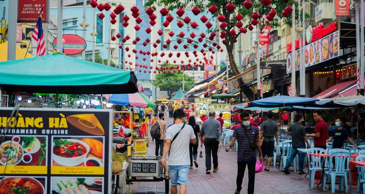 Mercado callejero peatonal bullicioso bordeado de puestos de comida y faroles coloridos colgando en lo alto en el Chinatown de Kuala Lumpur
