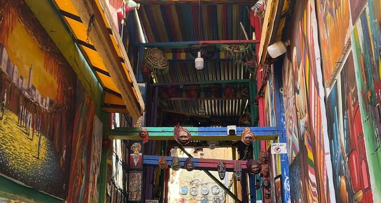 Vividly painted artistic alley with masks and murals creating a colourful tunnel-like passage.