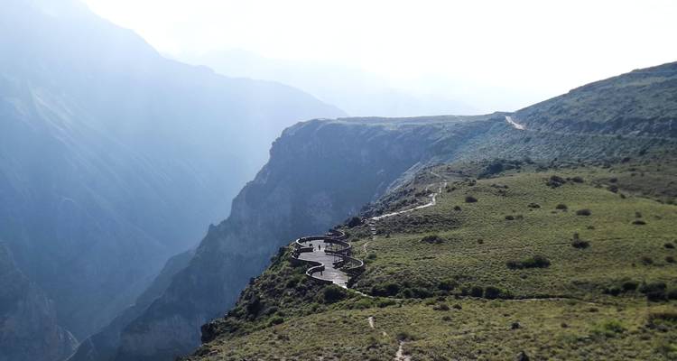 Plataforma de observación serpenteante encaramada en el borde de un acantilado escarpado sobre las profundidades brumosas del Cañón del Colca.