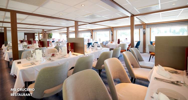 Helles, luftiges Restaurant auf einem Flusskreuzfahrtschiff mit ordentlich gedeckten Tischen und gepolsterten Stühlen.