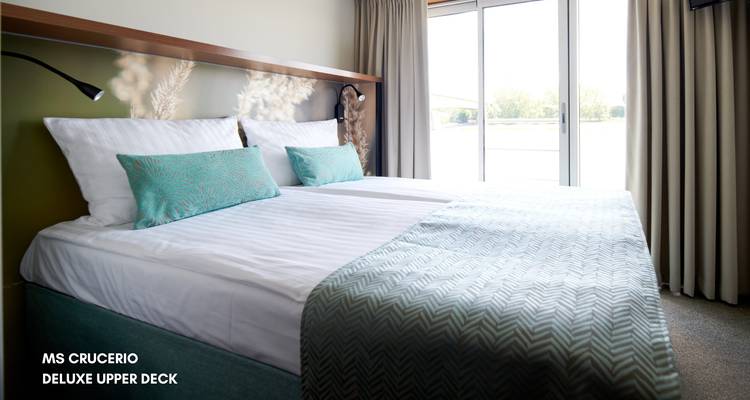 Luxe cruisehut op het bovendek met groot raam en frisse turquoise accenten.