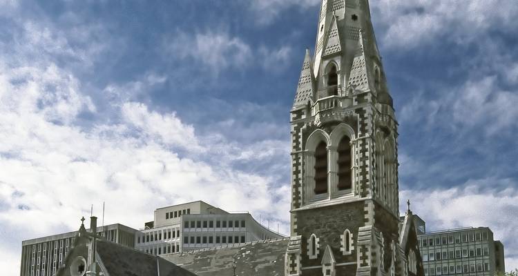 La flèche de pierre de la cathédrale de Christchurch s'élève contre un ciel partiellement nuageux.