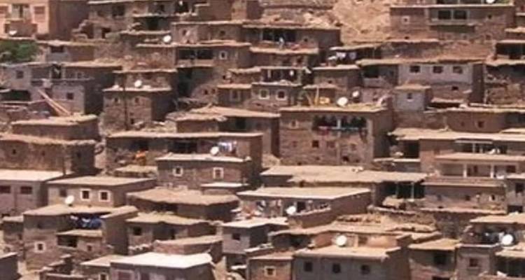 Close-up of stacked earthen houses and satellite dishes on a hillside in a traditional Moroccan village.