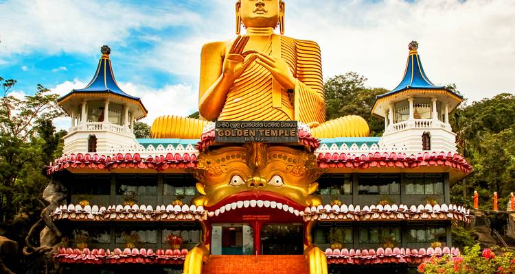 Massive goldene Buddha-Statue auf kunstvoller Tempelfassade, bekannt als Goldener Tempel von Dambulla