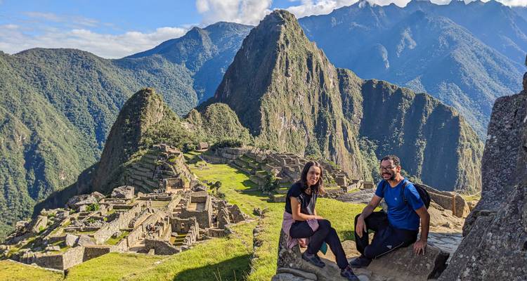 Deux voyageurs posant avec le pic emblématique du Machu Picchu et les terrasses de pierre derrière eux