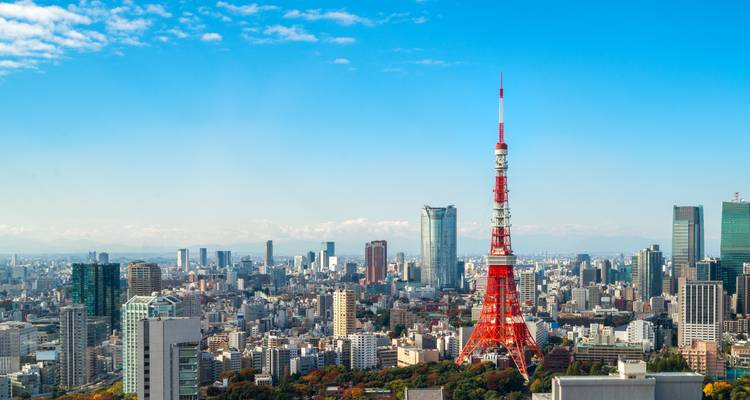 Tokio-Skyline mit dem roten Tokyo Tower, der über moderne Wolkenkratzer unter einem klaren blauen Himmel aufragt
