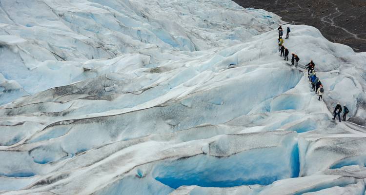 Avonturiers trekken in ganzenpas over het met spleten doorsneden blauwe ijs van de Perito Moreno Gletsjer.