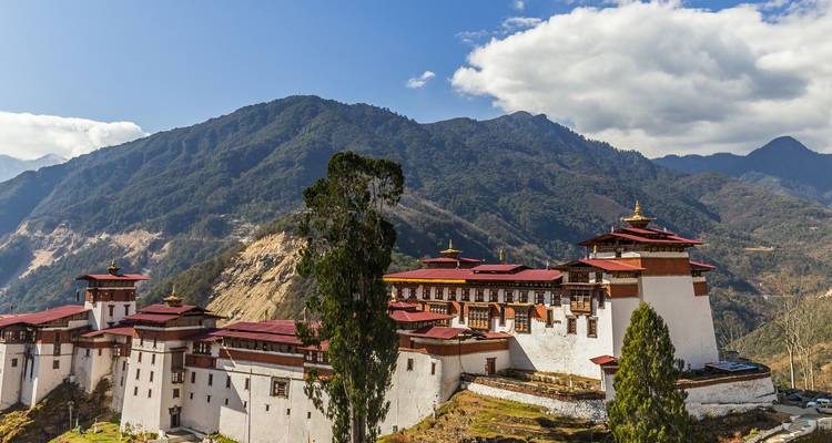Trongsa Dzong sprawls along a ridge with mountain backdrop and dramatic skies.