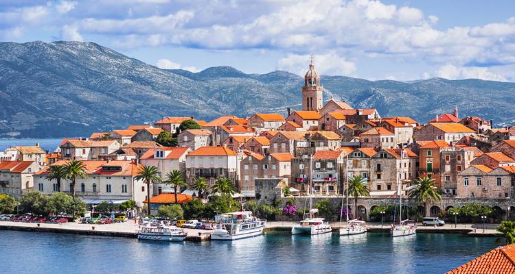 El casco antiguo medieval de Korčula con tejados de terracota se alza sobre el mar Adriático azul celeste.