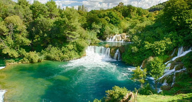 Smaragdgroene watervallen die door weelderige bospools stromen in Nationaal Park Krka