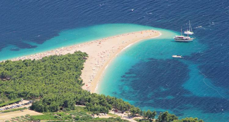 Vista aérea de la estrecha lengua de arena dorada de guijarros de Zlatni Rat rodeada por las aguas turquesas del Adriático frente a la isla de Brač.