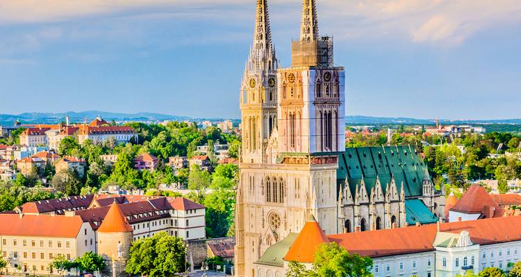 Les tours jumelles néo-gothiques de la cathédrale de Zagreb s'élevant au-dessus du paysage urbain aux toits verts et rouges