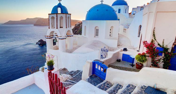 Les églises emblématiques aux dômes bleus de Santorin surplombent la mer Égée scintillante depuis des terrasses blanchies à la chaux.